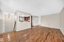 Hardwood flooring, neutral wall tones, interior pass-through window, built-in lighting fixture, and white trim throughout - 12721 117 Street Nw, Edmonton, AB 