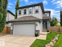 Two-story residence featuring light gray siding, a dark gray asphalt shingle roof, and an attached two-car garage - 16893 58A Street Nw, Edmonton, AB 