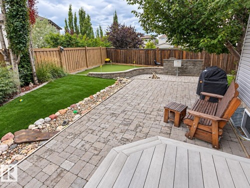 Paver patio with a built-in outdoor kitchen, fire pit, and putting green - 16893 58A Street Nw, Edmonton, AB 