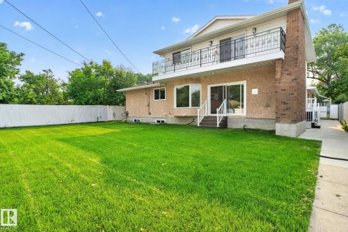 Expansive grassy yard with white perimeter fencing - 12121 42 Street Nw, Edmonton, AB - Outdoor With Balcony