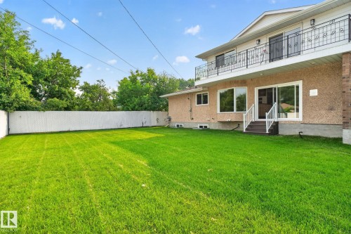 Expansive green lawn with a white privacy fence - 12121 42 Street Nw, Edmonton, AB - Outdoor With Balcony