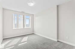 Bright room featuring light grey carpeting, white baseboards, and a large window with vertical blinds - 