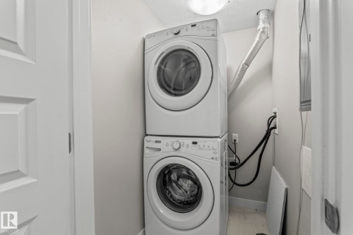Dedicated laundry area featuring a stacked washer and dryer unit - 5151 Windermere  Bv Sw, Edmonton, AB - Indoor Photo Showing Laundry Room