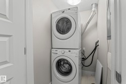 Dedicated laundry area featuring a stacked washer and dryer unit - 