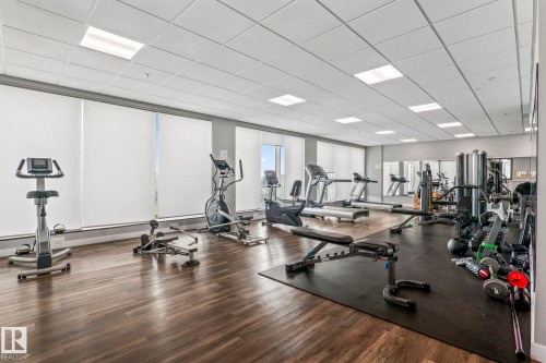 Fitness center featuring cardio and strength equipment, wood-finish flooring, recessed lighting, and wall-mounted mirrors - 5151 Windermere  Bv Sw, Edmonton, AB - Indoor Photo Showing Gym Room