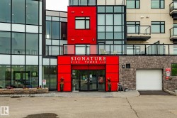 Modern building facade featuring vibrant red paneling and expansive glass windows - 