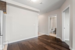 Dark wood-finish flooring extending through the entry, with light neutral wall tones - 