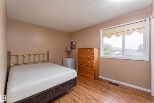 Wood-finish flooring, neutral wall color, and a large window with natural light - 17928 93 Ave Nw, Edmonton, AB 