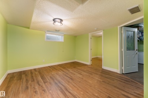 Wood-finish flooring, recessed ceiling lighting, light green wall paint, and white trim - 17928 93 Ave Nw, Edmonton, AB 