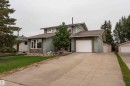 Split-level residence featuring a light green siding exterior, an attached single-car garage with a white door, and an additional detached single-car garage - 17928 93 Ave Nw, Edmonton, AB 