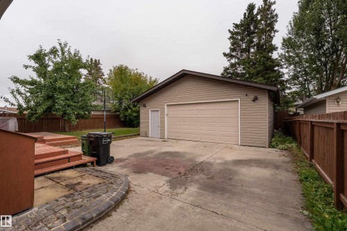 Detached garage with siding exterior, concrete driveway, and wood fence boundary - 17928 93 Ave Nw, Edmonton, AB 