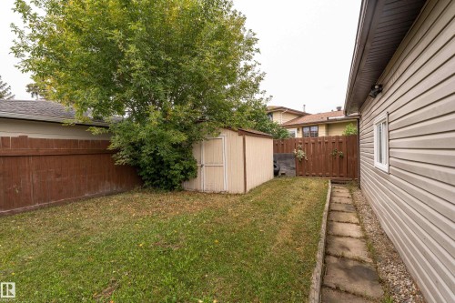 Expansive backyard featuring a manicured lawn, established landscaping, and a functional storage shed - 17928 93 Ave Nw, Edmonton, AB 