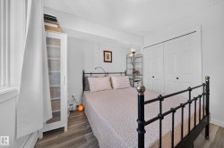 Wood-finish flooring, white bi-fold closet doors, and white walls - 