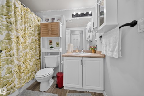 White vanity with a neutral countertop, undermount sink, and black hardware - #419 920 156 St Nw, Edmonton, AB 