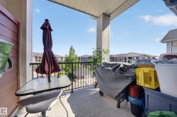 Outdoor balcony with textured flooring and a black metal railing - 