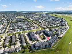 Expansive neighborhood setting featuring multi-story residential buildings, paved parking areas, and surrounding green spaces - 