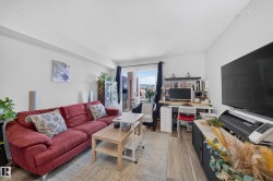 Wood-finish flooring throughout, white painted walls, and a sliding glass door to an exterior space - 