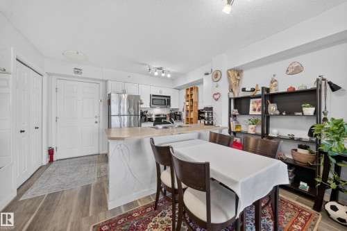 Kitchen featuring white cabinetry, stainless steel appliances, and a light-colored countertop - #419 920 156 St Nw, Edmonton, AB 