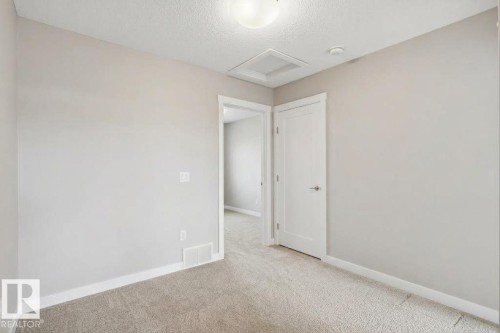 Light gray wall paint, white trim, recessed lighting, white panel door, and light-colored carpet - #12 1391 Starling Dr Nw, Edmonton, AB 