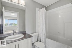 White bathroom vanity with an integrated sink and chrome faucet, set against a grey wall - 