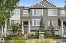 Multi-level townhouse exterior featuring multiple window styles, columns at the entry, and an integrated landscaping bed with plantings - #12 1391 Starling Dr Nw, Edmonton, AB 