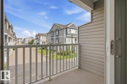 Balcony with textured flooring, white railings, and siding exterior - 