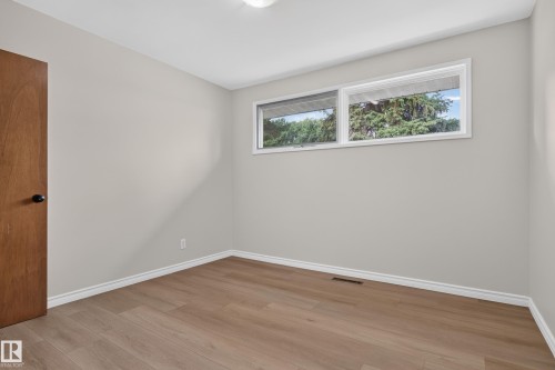 Light gray painted walls, wood-finish flooring, white trim, and a white ceiling with a flush-mount light fixture - 2 Grandora Crescent, St. Albert, AB 