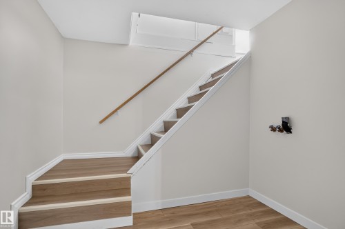 Staircase featuring wood-finish treads, white risers, and a natural wood handrail - 2 Grandora Crescent, St. Albert, AB 