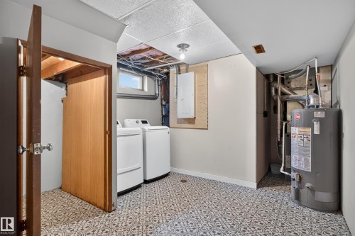 Laundry area featuring patterned tile flooring, an exposed ceiling, and a water heater - 2 Grandora Crescent, St. Albert, AB 