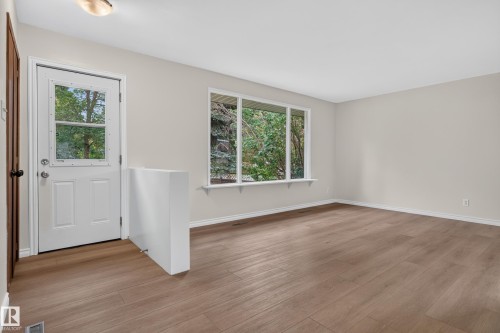 Wood-finish flooring throughout, neutral paint finishes, large window, and a white entry door with glass paneling - 2 Grandora Crescent, St. Albert, AB 