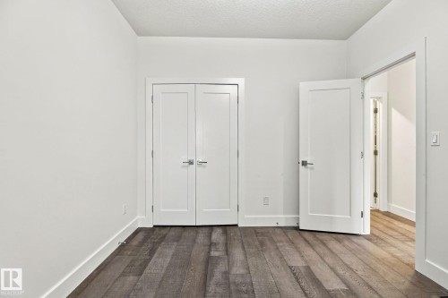 Wood-finish flooring, white walls, and bright white trim - 4530 Saly Place Sw, Edmonton, AB 