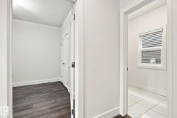 Hallway featuring wood-finish flooring and white interior doors - 