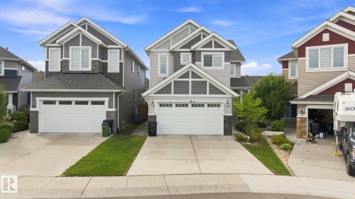 Two-story residential architecture featuring a gabled roof, horizontal siding, and stone veneer accents - 4530 Saly Place Sw, Edmonton, AB 
