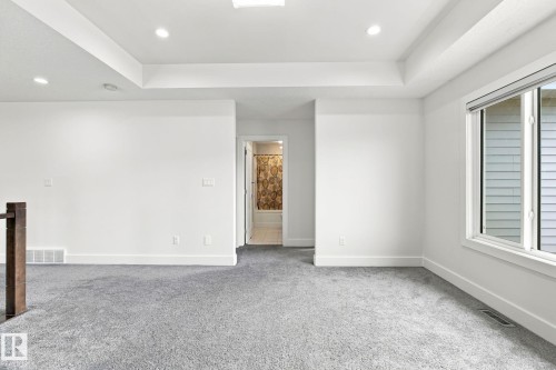 Tray ceiling with recessed lighting, large window, and gray carpeting - 4530 Saly Place Sw, Edmonton, AB 