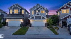 Two-story residence featuring a two-car garage, stone accents, and varied siding textures - 