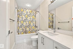 Bathroom featuring a vanity with an integrated sink, polished chrome faucet, and expansive wall-mounted mirror - 