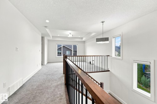 Upper landing with tray ceiling, recessed lighting, and modern pendant fixture - 4530 Saly Place Sw, Edmonton, AB 