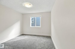 White walls with grey carpet flooring, a single window, and a flush-mount ceiling light - 