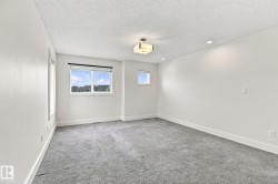 Bright interior with light gray carpeting, a window, a smaller window, and recessed lighting - 