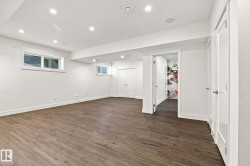 Spacious room featuring wood-finish flooring, recessed lighting, and multiple windows - 