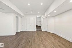 Recessed lighting illuminates the expansive room featuring wood-finish flooring - 