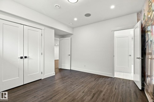 Wood-finish flooring, recessed lighting, and white walls throughout - 4530 Saly Place Sw, Edmonton, AB 
