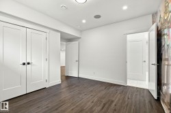 Wood-finish flooring, recessed lighting, and white walls throughout - 