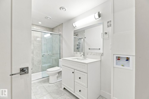 White shaker vanity with a single basin sink and stone countertop - 4530 Saly Place Sw, Edmonton, AB 