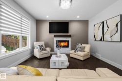 Wood-finish flooring, recessed lighting, and a white stone-clad fireplace with a wood mantel - 