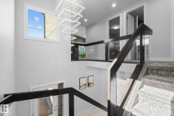 Staircase featuring dark wood-finish railings, glass balusters, and carpeted treads - 