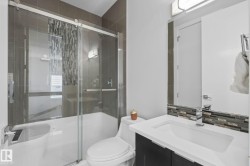 Modern bathroom featuring a vanity with an integrated sink, polished chrome faucet, and a large mirror - 
