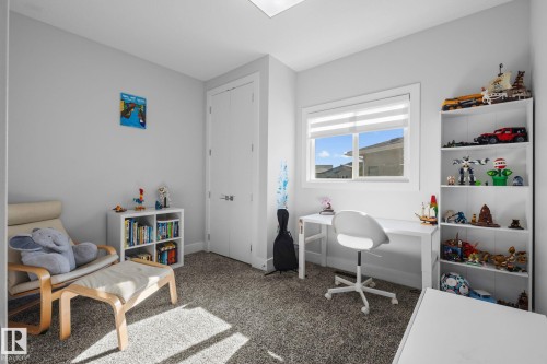 Recessed ceiling light fixture, window with horizontal blinds, built-in shelving, light gray wall paint, and gray carpet flooring - 2019 Ware Rd Nw, Edmonton, AB 