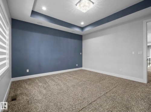 Tray ceiling with recessed lighting and a decorative light fixture, wall-to-wall carpeting, and a window with horizontal blinds - 2019 Ware Rd Nw, Edmonton, AB 