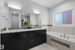 Dual vanity with integrated sinks, white countertops, and dark wood-finish cabinetry - 